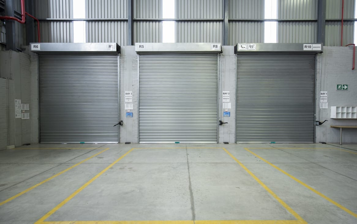 Commercial garage door repair team working in Los Angeles warehouse